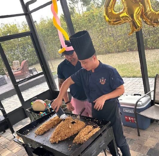 Hibachi chef preparing fried rice in animal shapes on a griddle